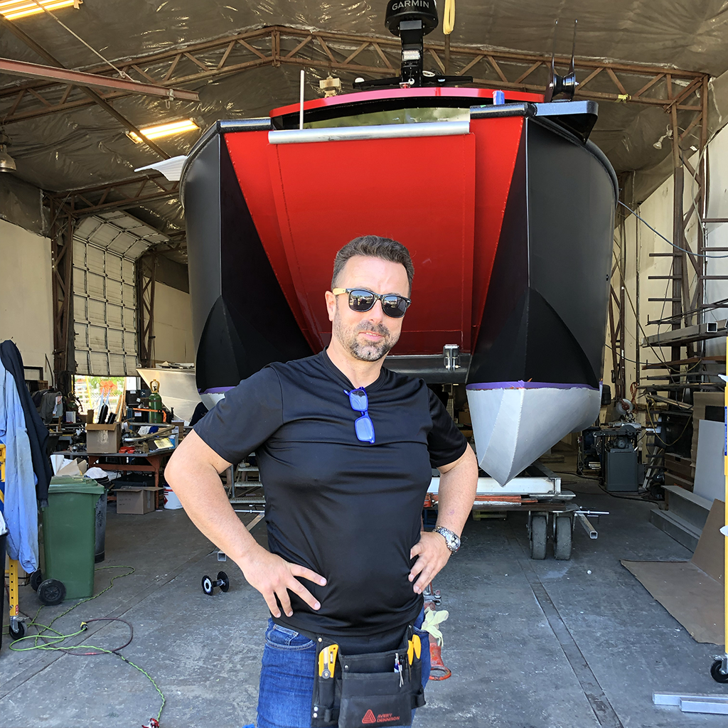 Sasa in front of wrapped catamaran