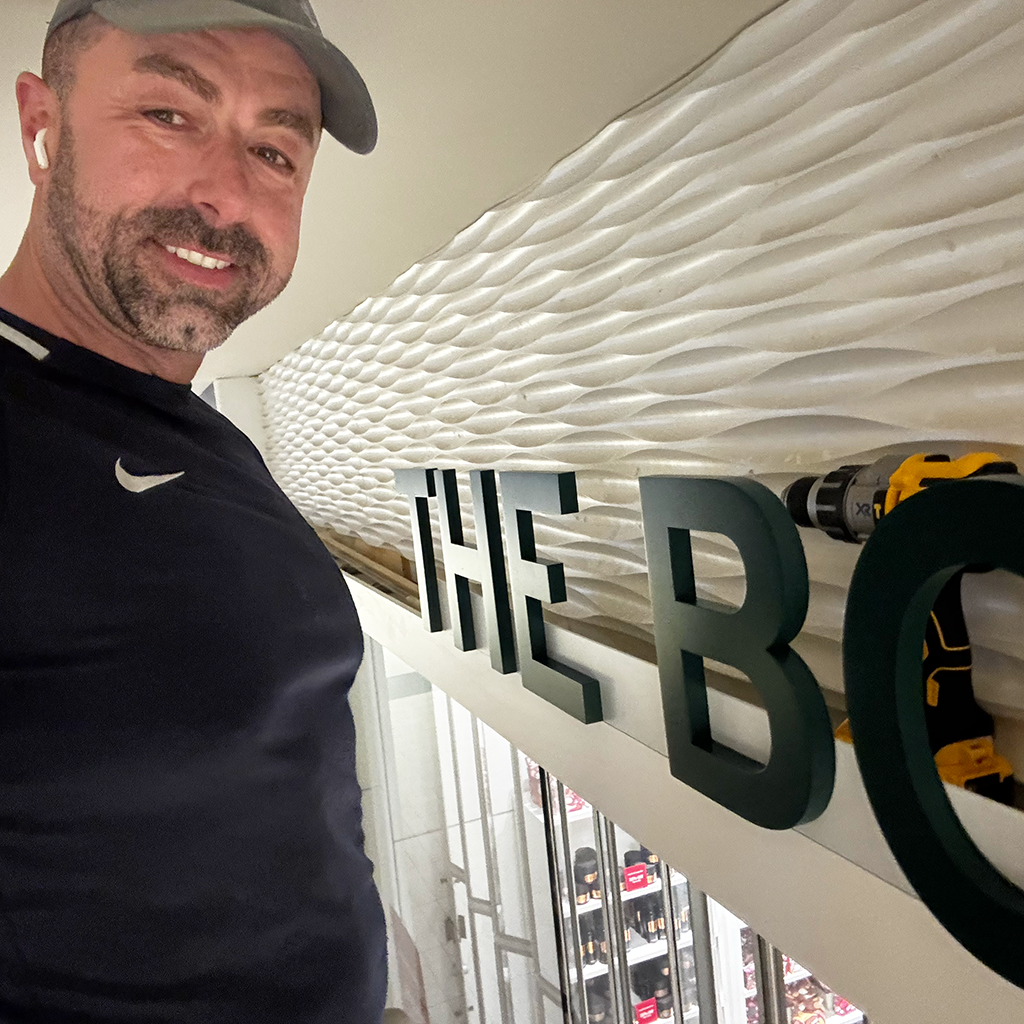 Sasa installing store sign